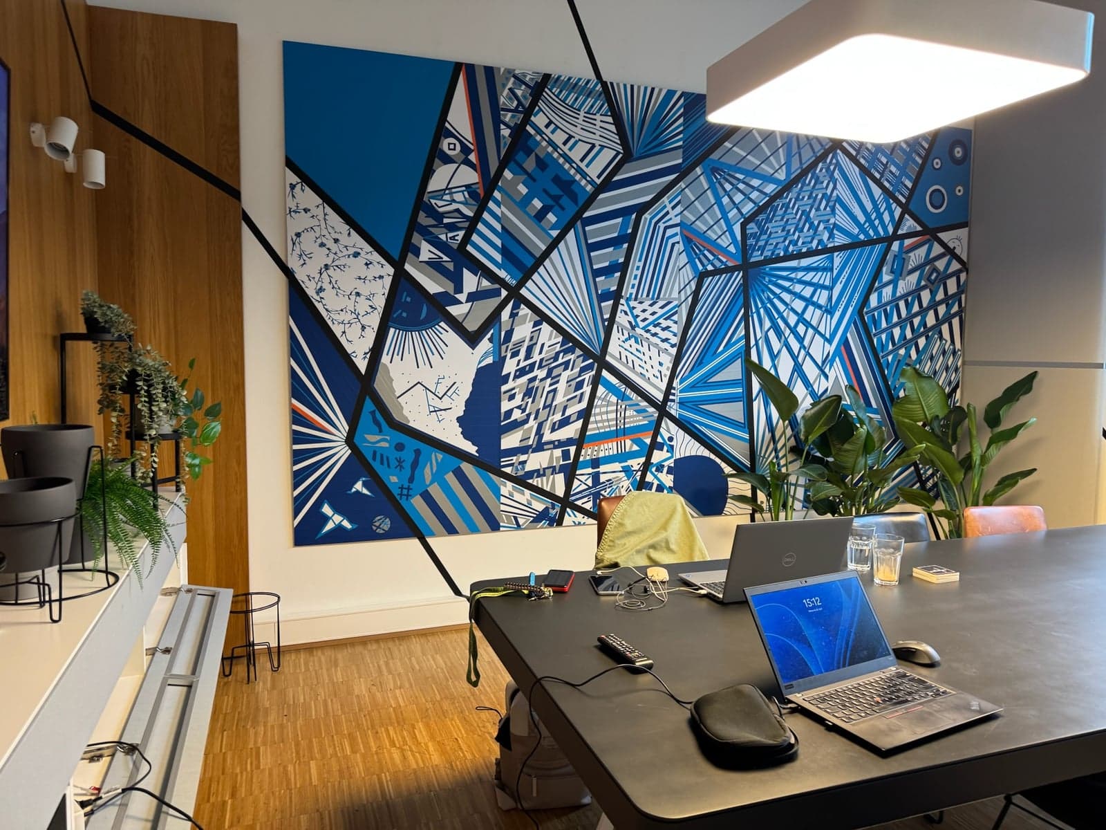 Schreibtisch im VANCADO-Studio mit Notebook und Kunstwand